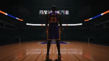 NBA center in Utah Jazz uniform standing on basketball court in dramatic arena lighting