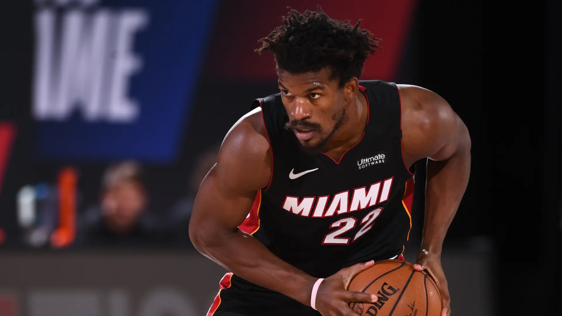 Jimmy Butler dribbling a basketball, wearing Miami Heat jersey in a game.