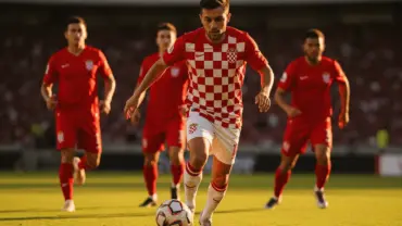 Croatian soccer player in checkered jersey attacking against Panama defenders during World Cup match