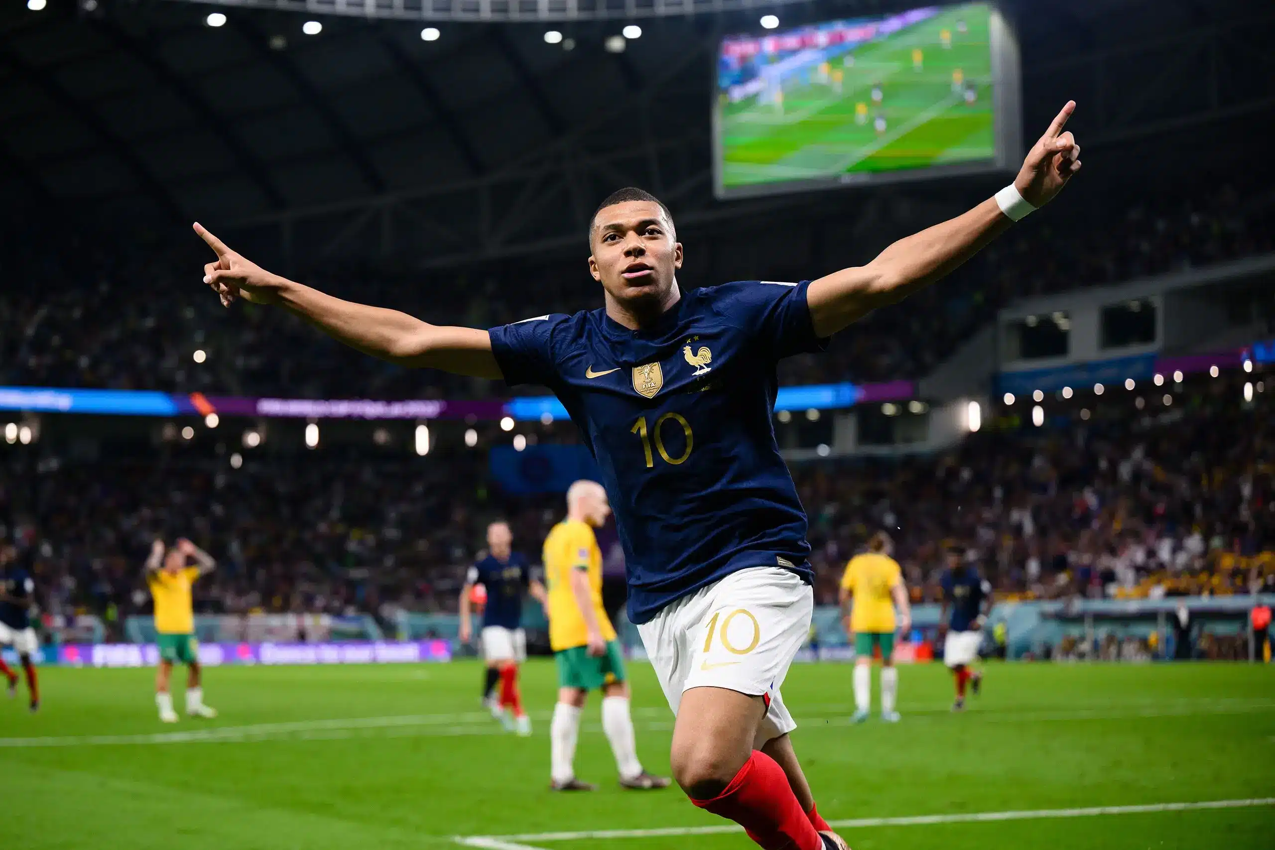 Kylian Mbappe celebrating a goal while playing for France against an opponent.