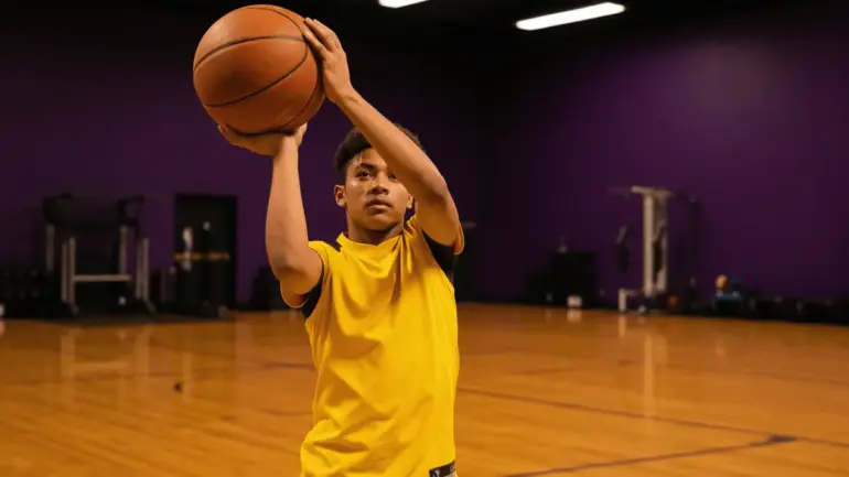 Basketball player shooting during Lakers pre-draft workout in professional training facility