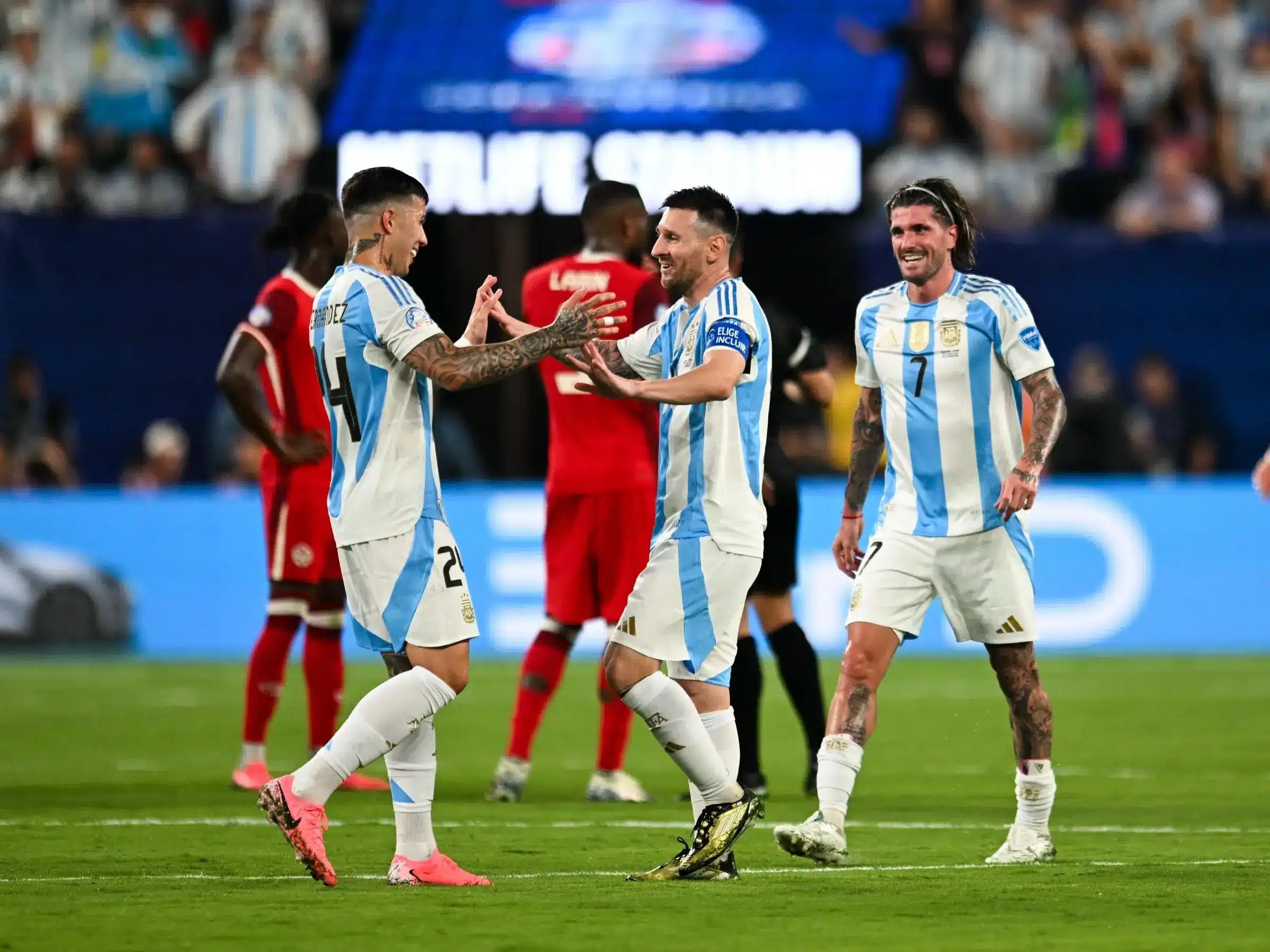 Lionel Messi and teammates celebrating during an Argentina football match.