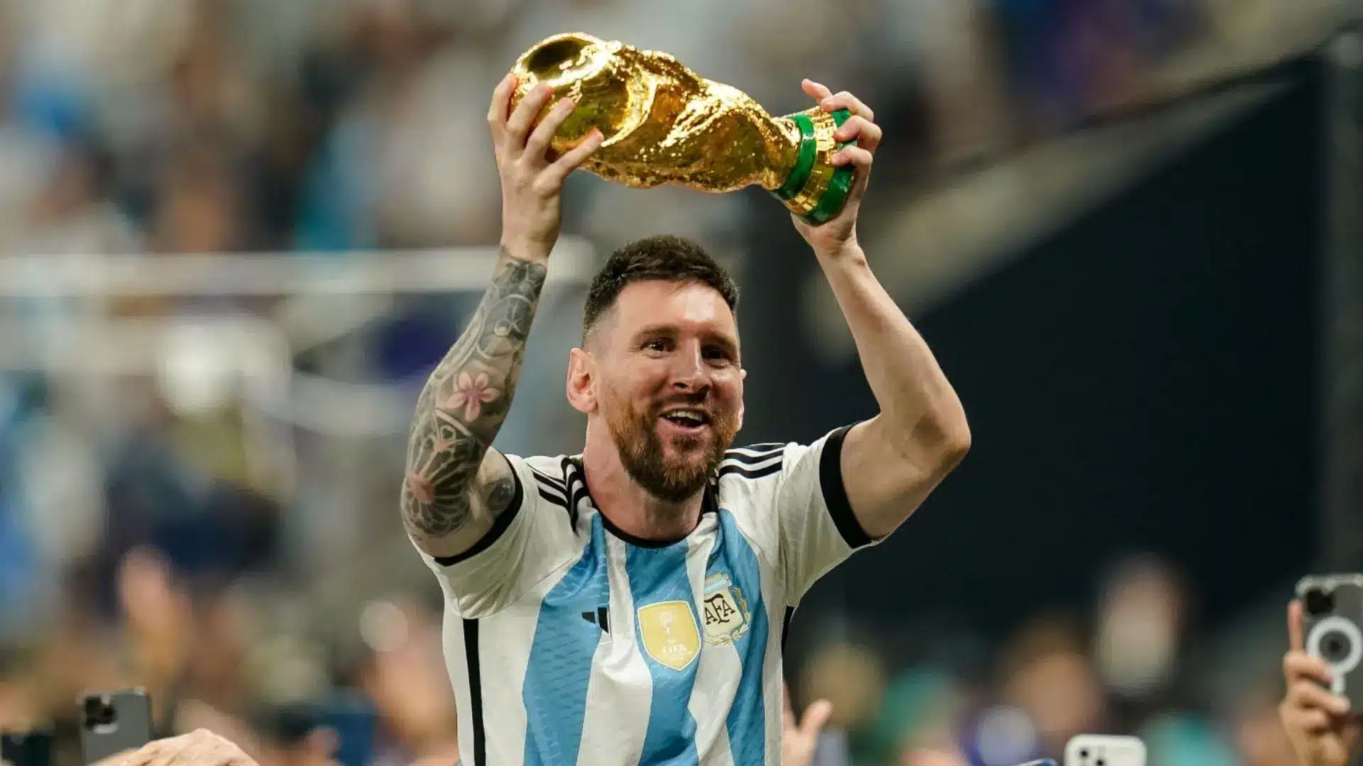 Lionel Messi celebrates holding the FIFA World Cup trophy for Argentina.