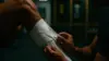 Athletic trainer taping hamstring injury in NFL training facility with green and gold team colors