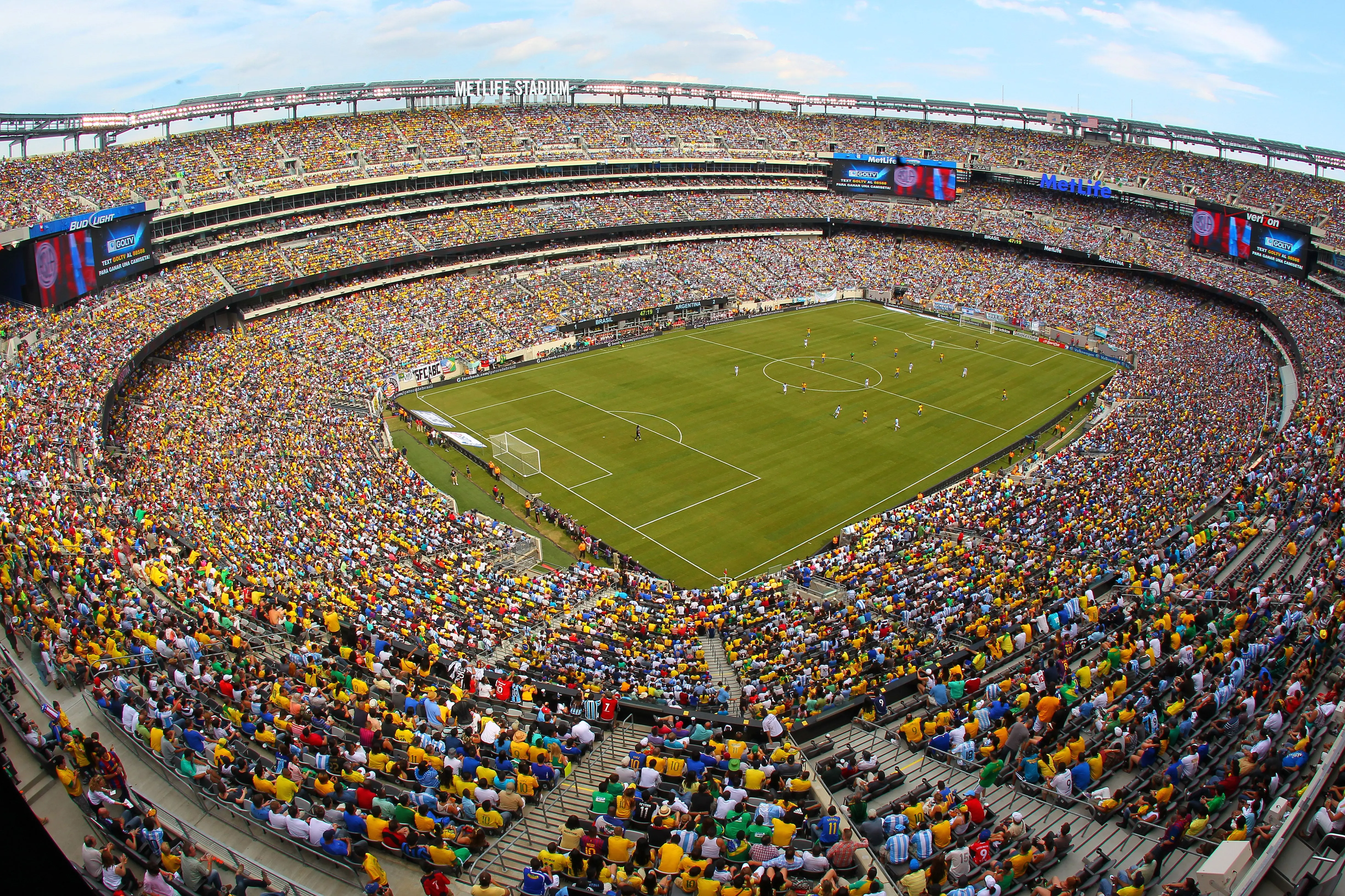 A packed MetLife Stadium during a soccer match with fans in team colors.