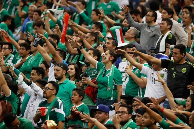 Passionate Mexico national football team fans celebrate during a match.