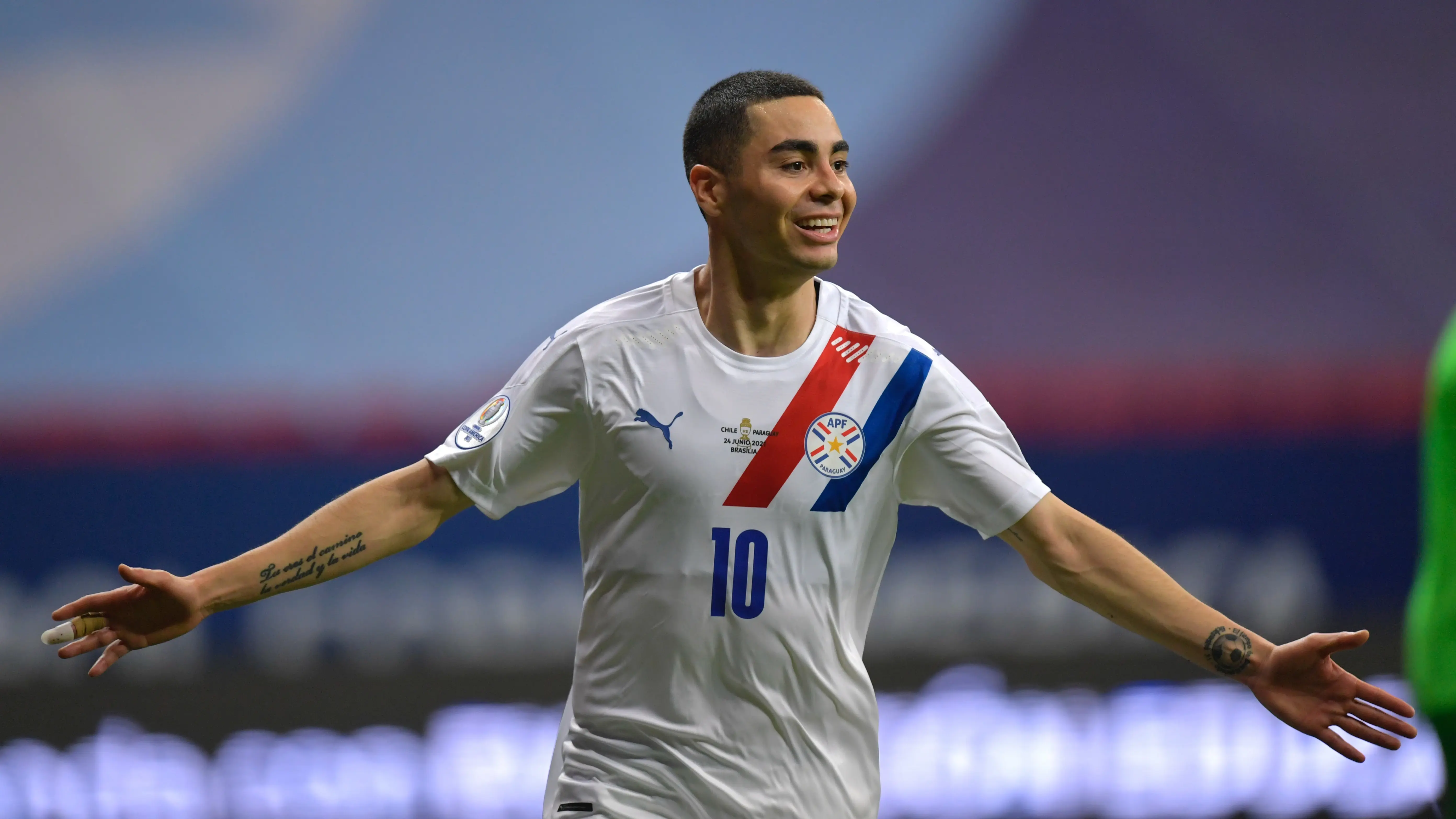 Miguel Almiron celebrating a goal wearing Paraguay jersey 10 during a match.