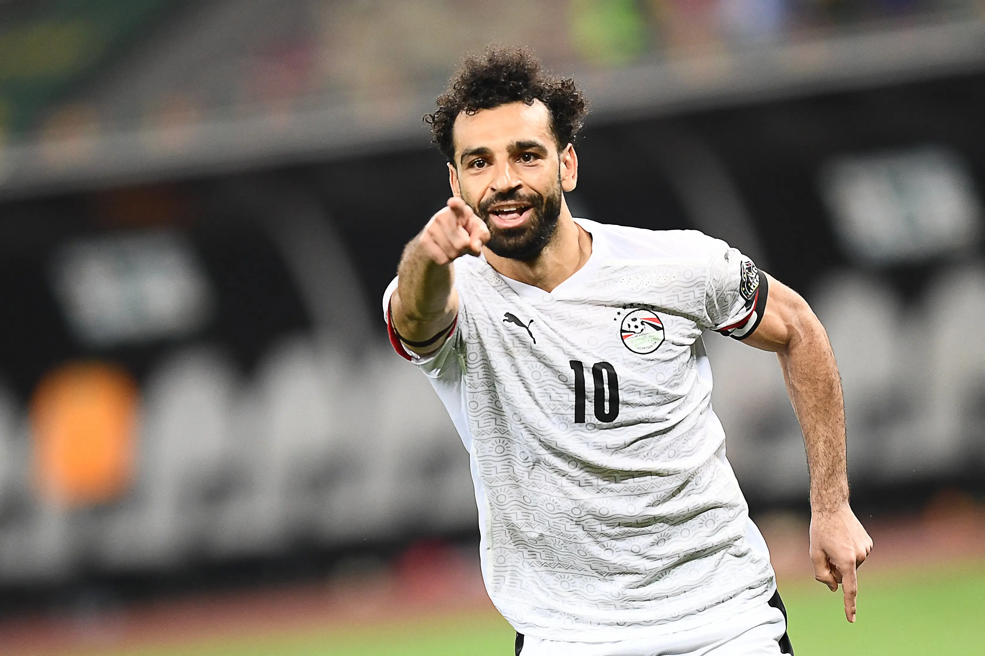 Mohamed Salah celebrating in a white Egypt national team jersey with number 10.