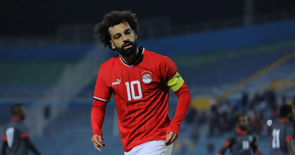 Mohamed Salah wearing a red Egypt jersey with the number 10 on the field.