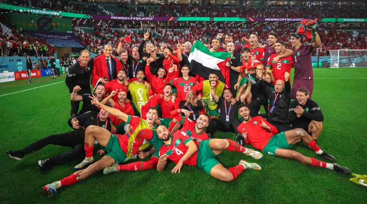 Morocco national football team celebrates victory with fans after a World Cup match.
