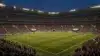 Packed World Cup stadium at night with illuminated soccer pitch and crowd during international match