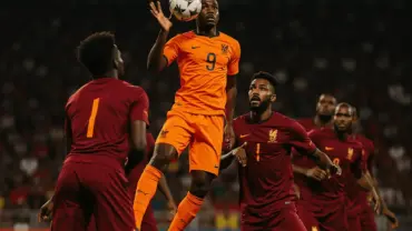 Netherlands striker competing for header against Morocco defenders in World Cup knockout match