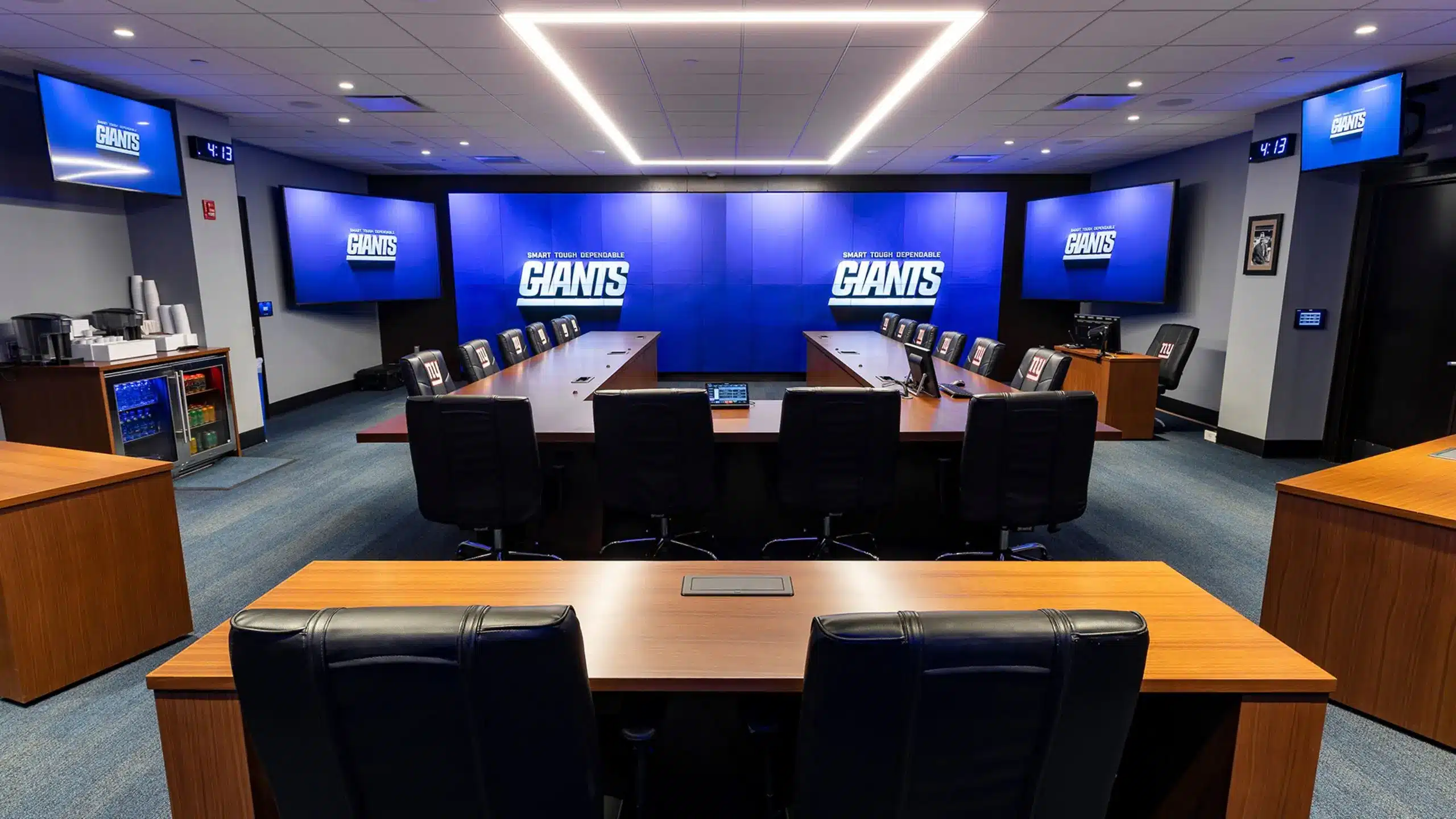 Interior of the New York Giants draft war room with seating and large screens.