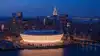 Madison Square Garden illuminated at night with New York City skyline in background