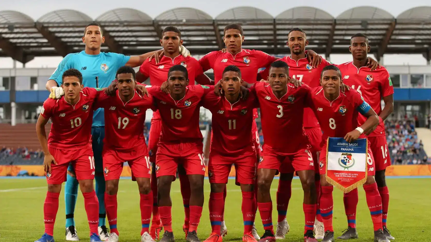 Panama national football team posing together in red kits during a match.