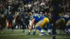 LA Rams offensive lineman in blue jersey at line of scrimmage in three-point stance during NFL game