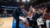 NBA assistant coach speaking intensely to head coach during Finals timeout huddle on the bench