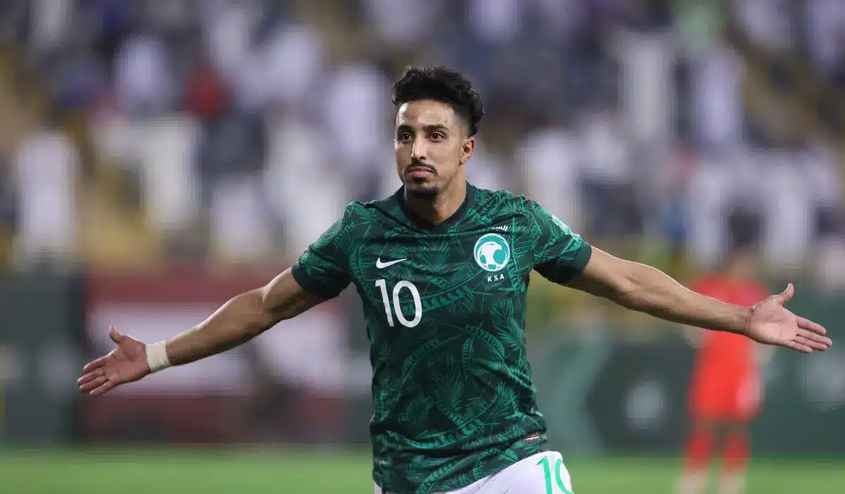 Salem Al-Dawsari celebrating in a green Saudi Arabia national team jersey.