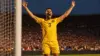 Soccer player celebrating goal during World Cup match in packed stadium with dramatic lighting