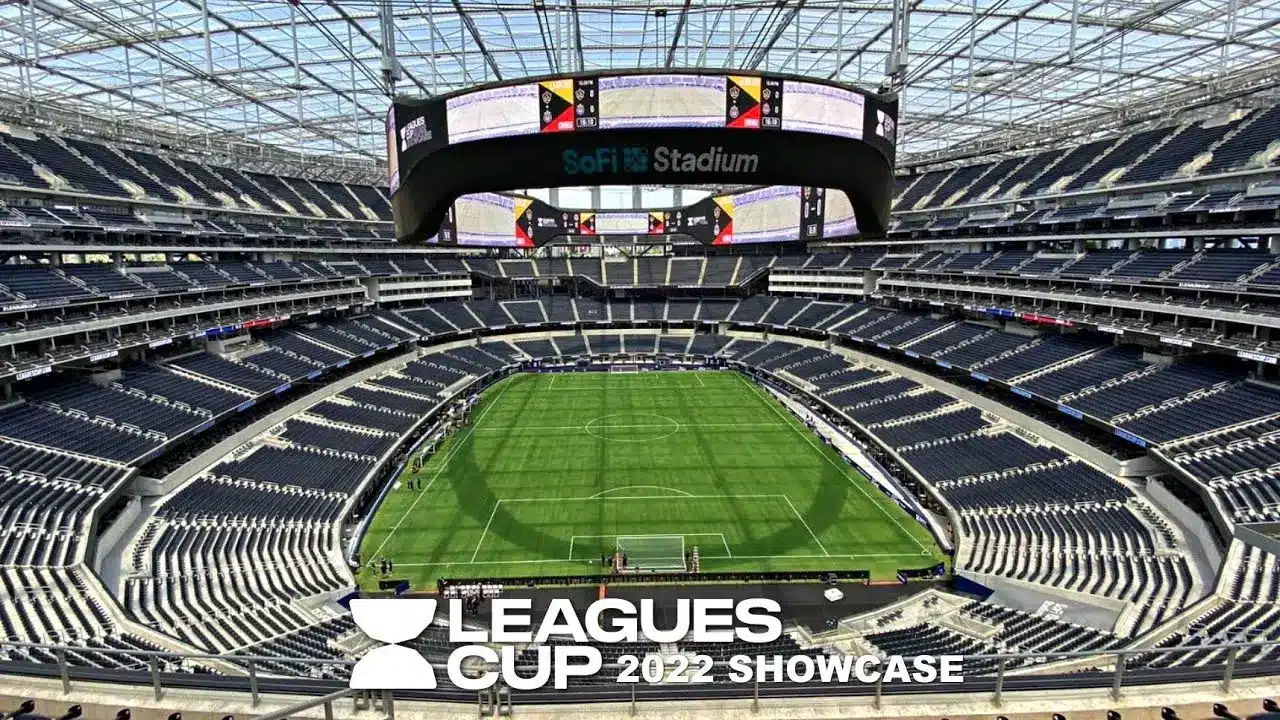 SoFi Stadium interior with a soccer field and large screens showing a match.