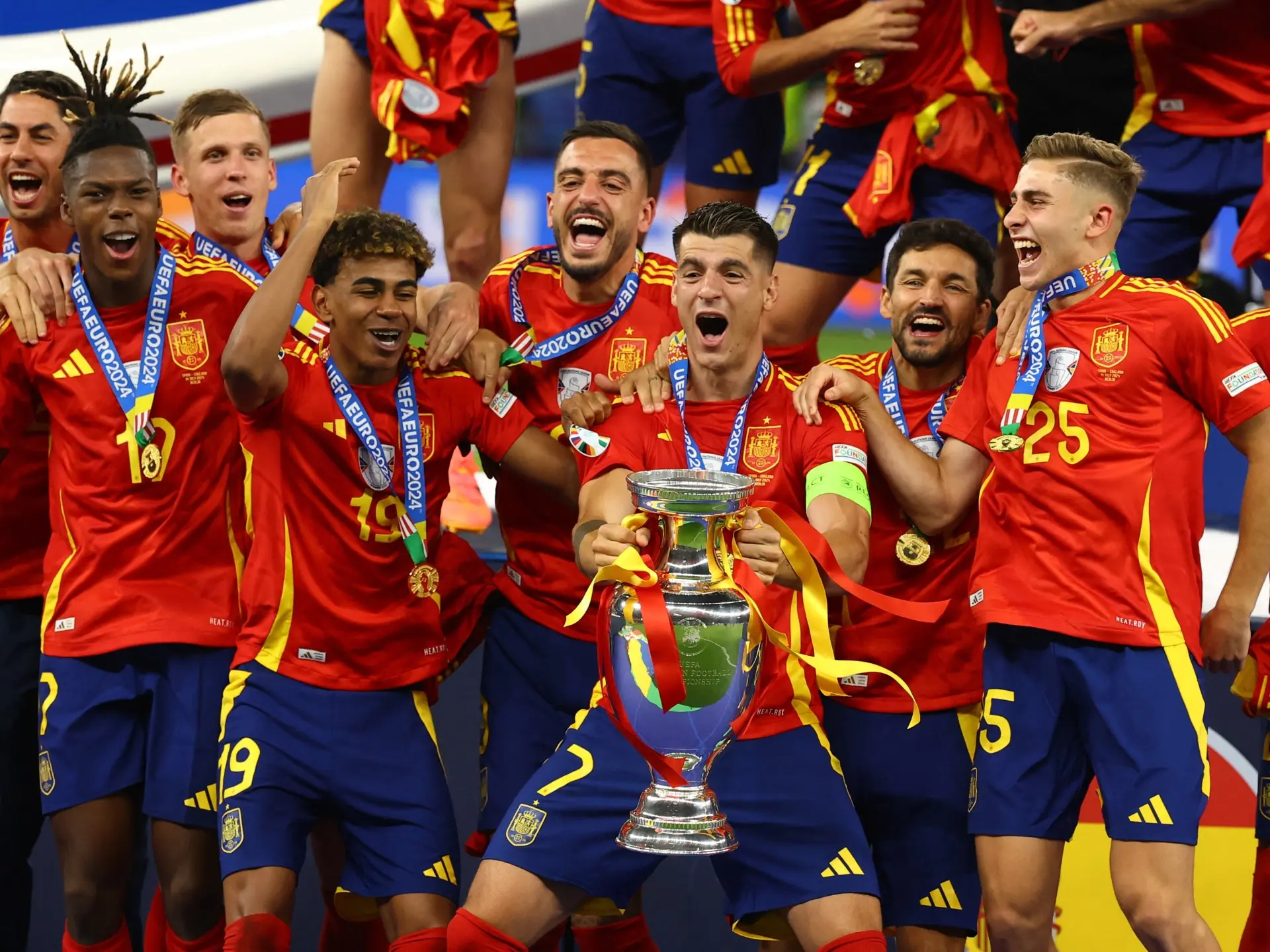 Spain national football team players celebrating with the UEFA Euro 2024 trophy.