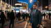 Protective father figure outside Madison Square Garden at night amid crowd tension
