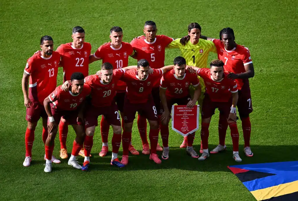 Switzerland national football team posing with a banner during a match.