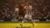 Two soccer players battling for ball possession in intense World Cup match under stadium lights