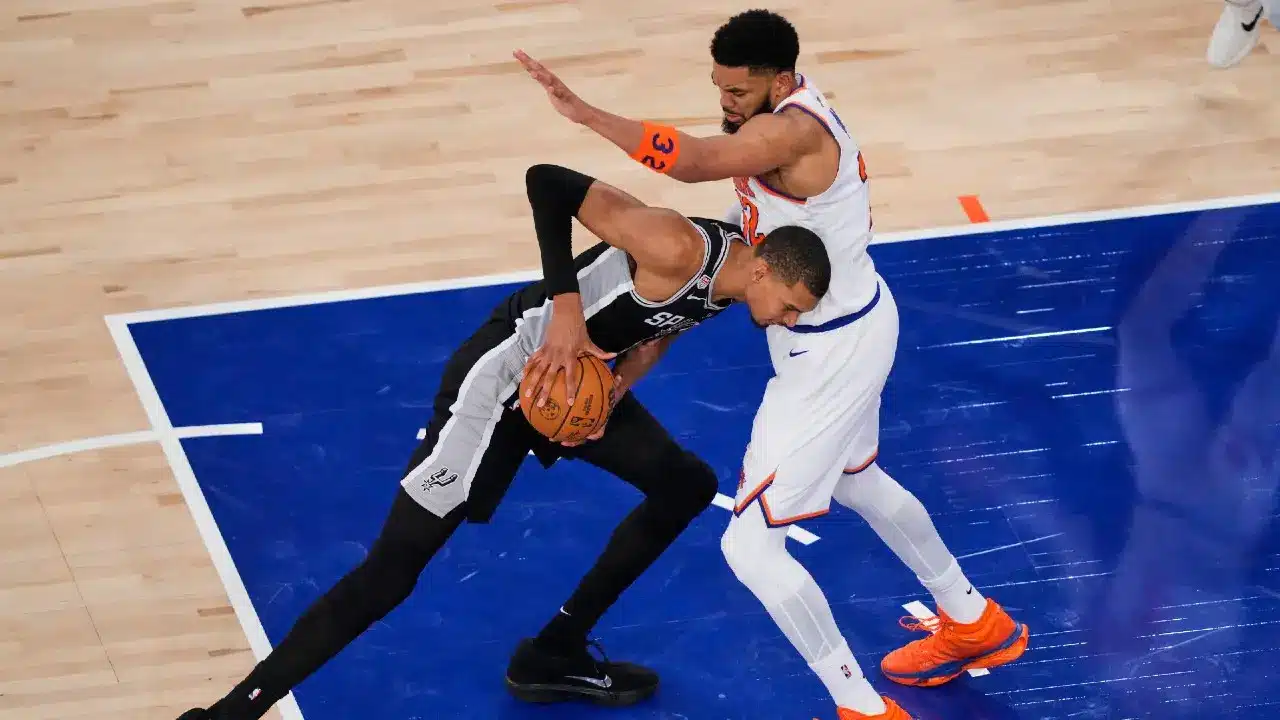 Victor Wembanyama of Spurs dribbling the ball against a Knicks player.