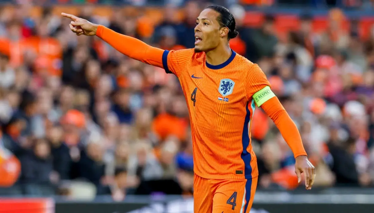 Virgil van Dijk in an orange Netherlands national team jersey, directing play during a match.