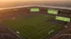 Modern soccer stadium at golden hour with illuminated pitch for World Cup 2026 betting coverage
