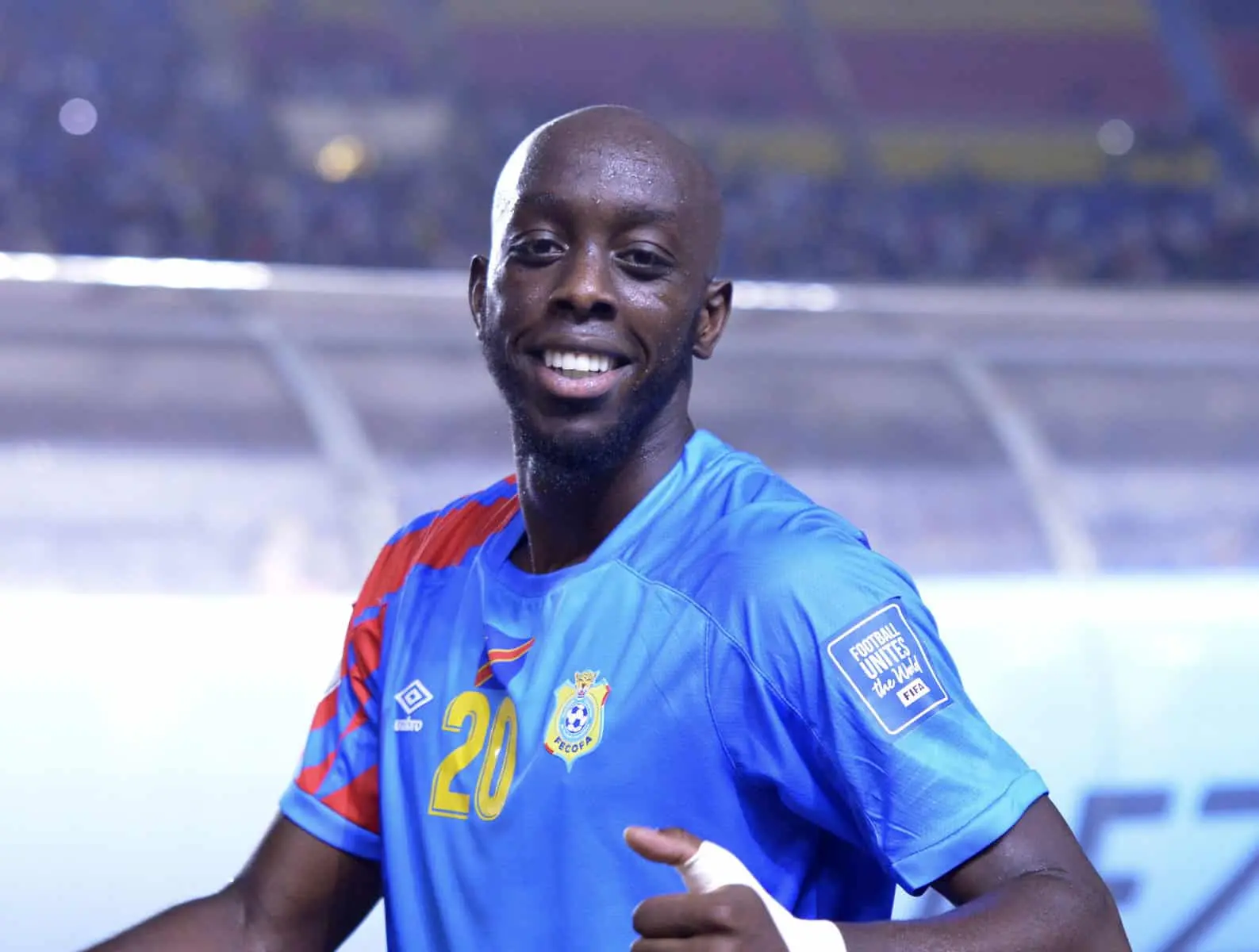 Yoane Wissa celebrating on the field wearing a blue DR Congo jersey.