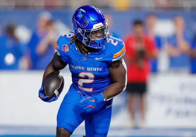 Boise State running back in blue uniform carrying football during a game