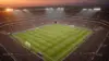 Soccer stadium at twilight with floodlights illuminating the pitch during World Cup knockout rounds