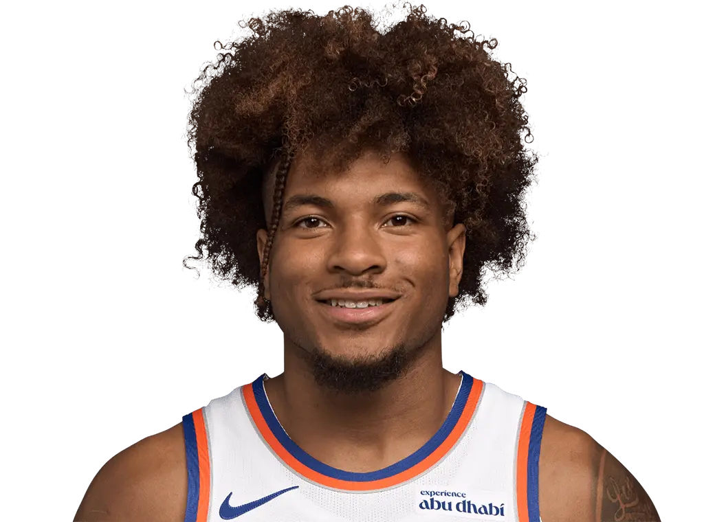 Headshot of New York Knicks player Deuce McBride wearing a white team jersey against a black background