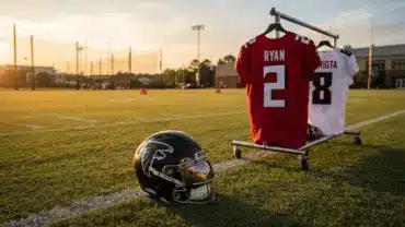 Atlanta Falcons helmet and quarterback jerseys on practice field representing QB competition