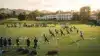 New York Giants players practicing drills at training camp with resort architecture in background