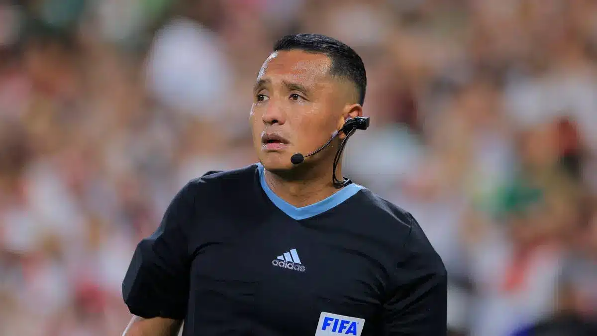 Referee Ivan Barton officiating a soccer match wearing a FIFA badge.