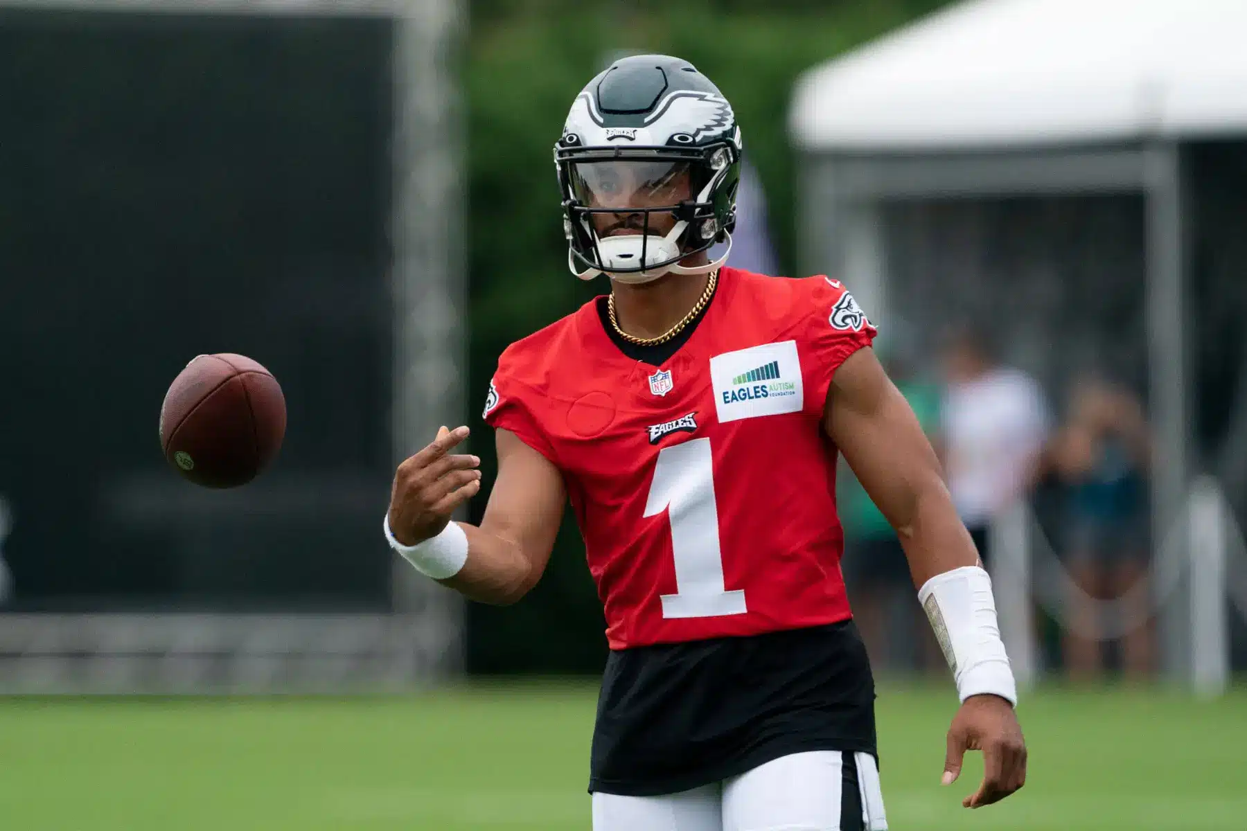 Philadelphia Eagles quarterback Jalen Hurts in a red practice jersey and helmet during training camp.
