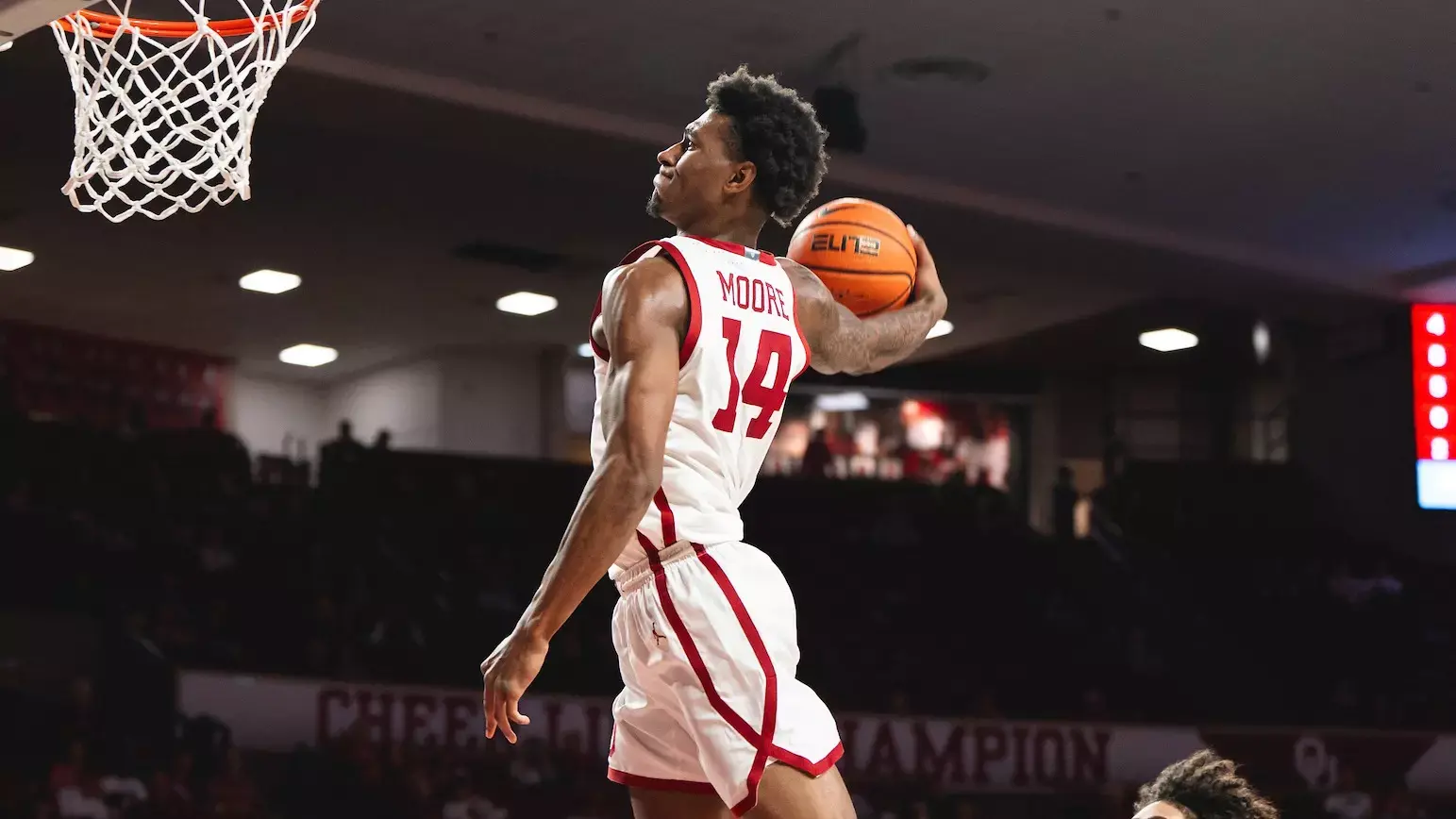 Jalon Moore performing a slam dunk during a basketball game.