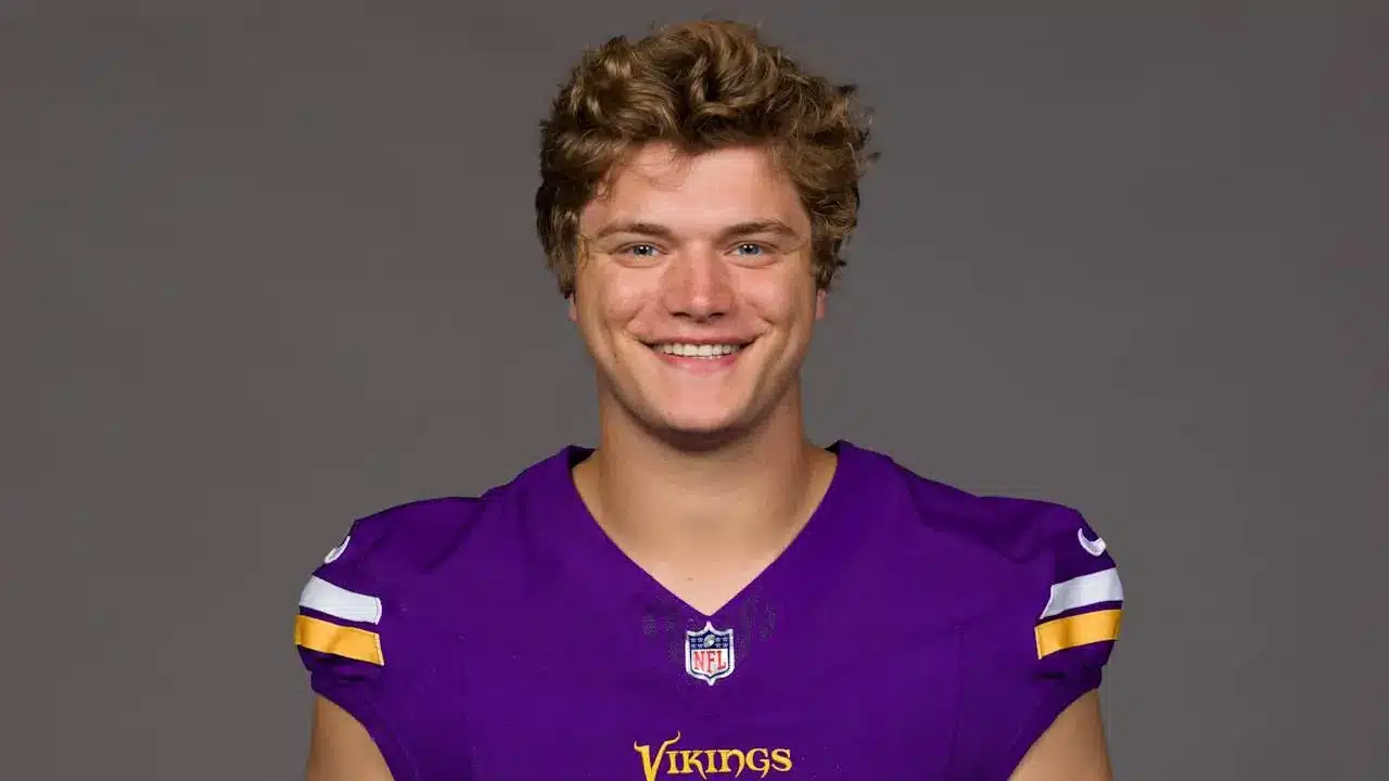 Portrait of a smiling young man in a Minnesota Vikings jersey.