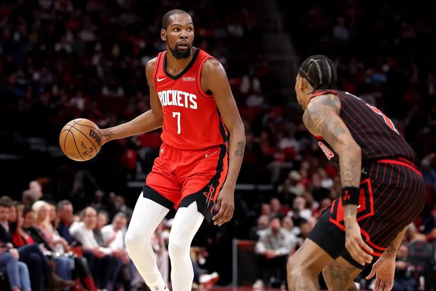 Kevin Durant dribbling a basketball while wearing a red Houston Rockets jersey during an NBA game