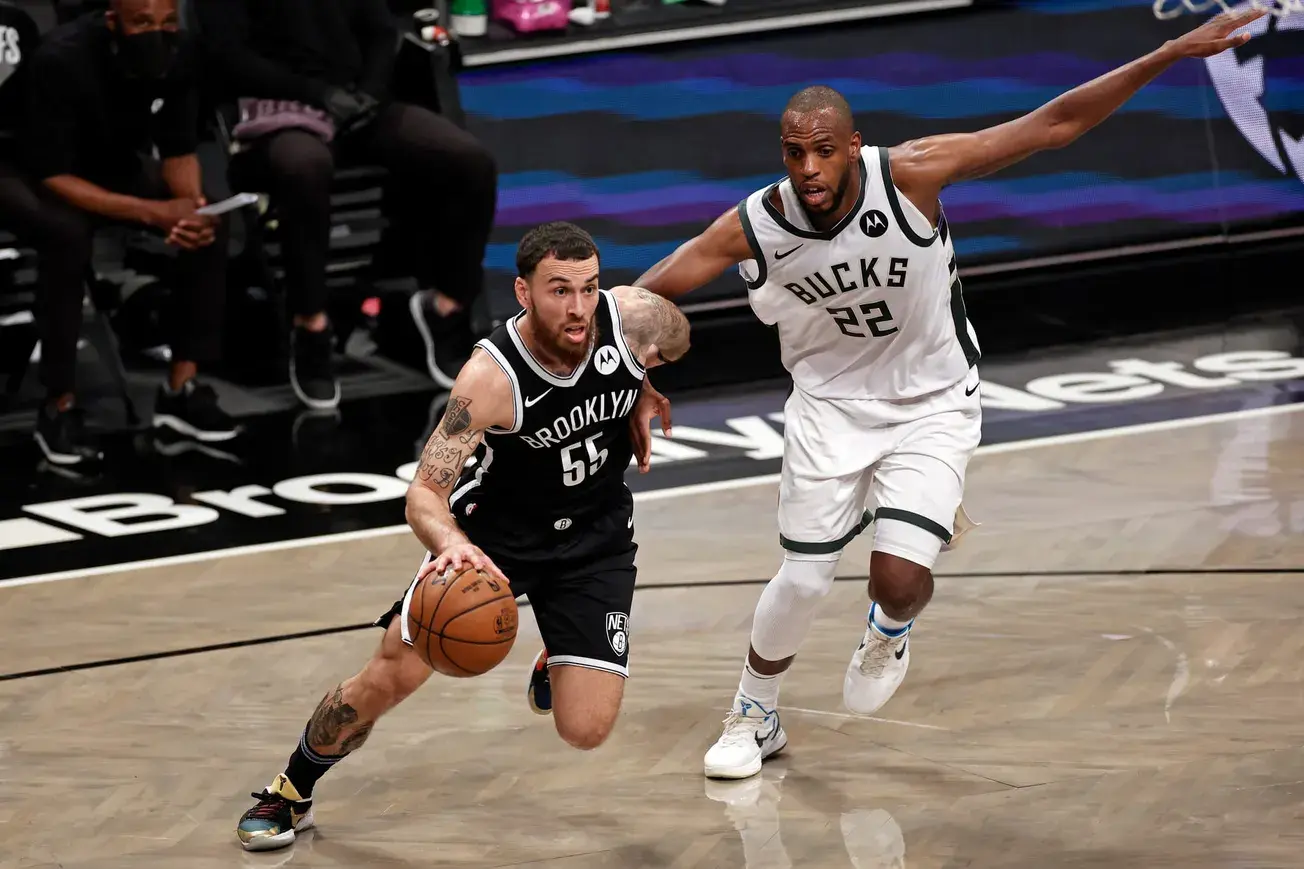 Khris Middleton pursuing Brooklyn player during a basketball game.