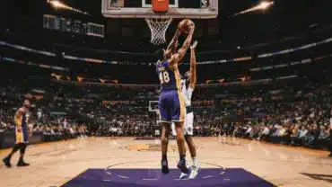 Lakers player securing defensive rebound in the paint during NBA game action
