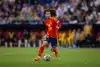 Marc Cucurella in Spain national team kit dribbling the ball during a match.