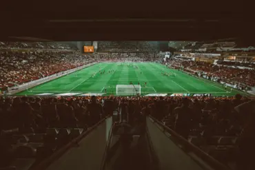 View of a packed stadium during a soccer match with players on the field.