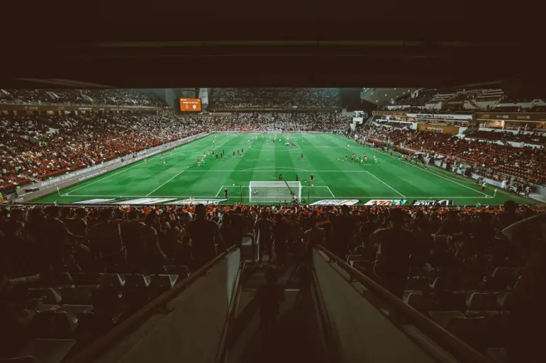 View of a packed stadium during a soccer match with players on the field.