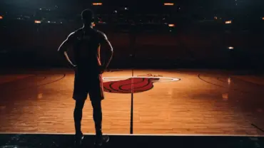 Miami Heat basketball court with player silhouette under dramatic arena lighting