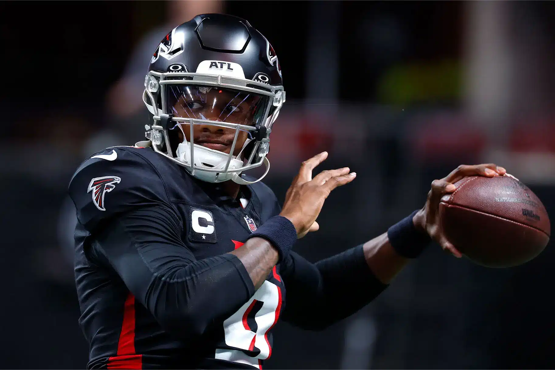Atlanta Falcons quarterback in action wearing black jersey and helmet with ATL logo.