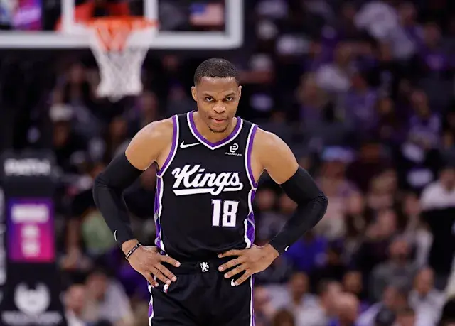 Russell Westbrook in a Kings jersey, with arms on hips during a game.
